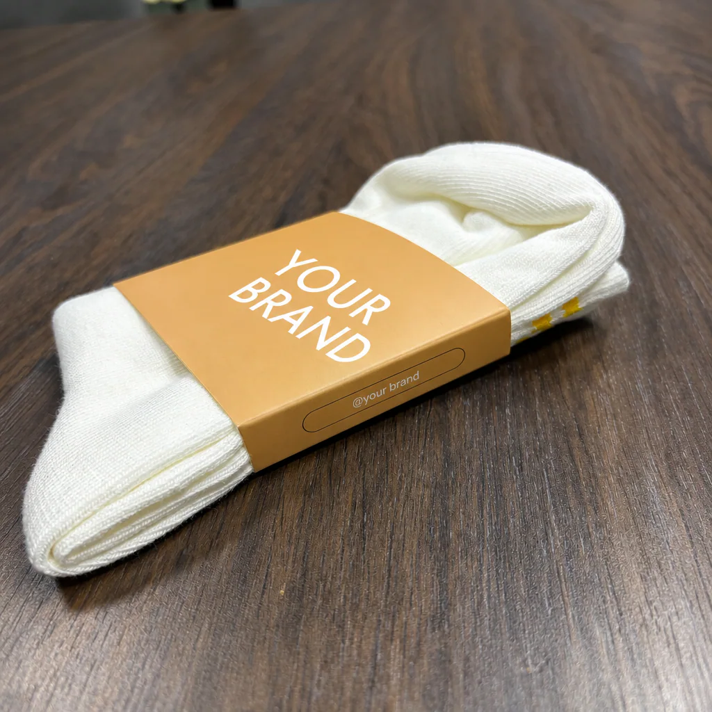 Angled view of a physical custom paper sleeve fitted around a folded white grip sock