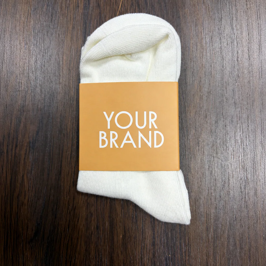 Front branding panel on a physical custom paper sleeve fitted around a white grip sock