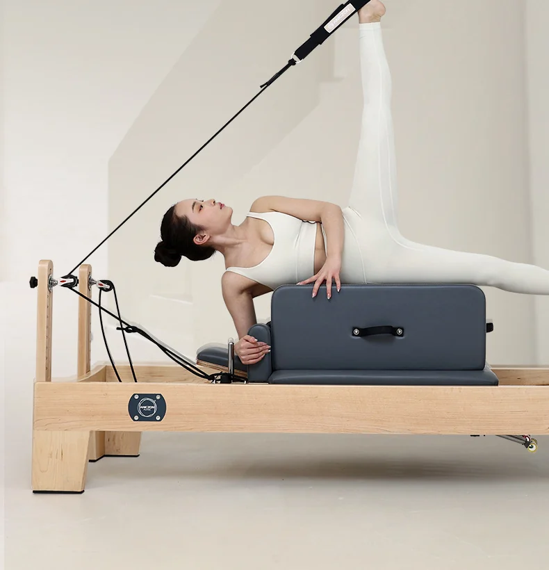 Woman training on a wooden Pilates reformer
